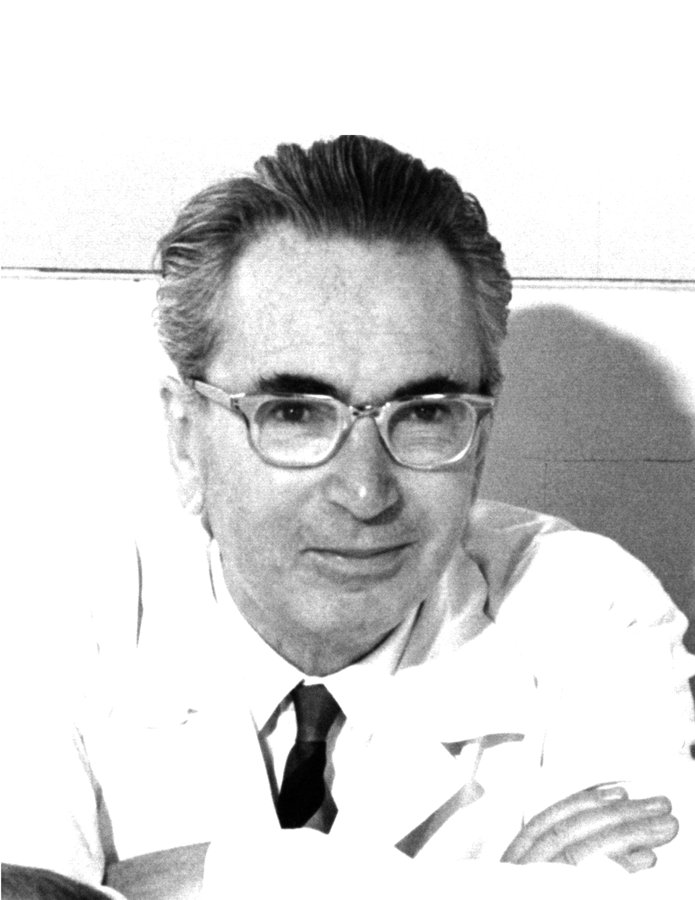Retrato en blanco y negro de Viktor Frankl con anteojos, sonriendo, en su consultorio
